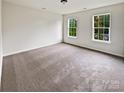 Bright bedroom features neutral carpet, two windows, and ample natural light at 18414 Victoria Bay Dr, Cornelius, NC 28031