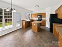 Functional kitchen with island, tile floor, and natural light from a door to the backyard at 18414 Victoria Bay Dr, Cornelius, NC 28031