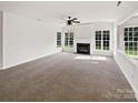 Spacious living room boasts a fireplace, ceiling fan, and multiple windows at 18414 Victoria Bay Dr, Cornelius, NC 28031