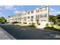 Attractive townhomes offer convenient garages, colorful doors, and neatly landscaped front yards along the street at 2037 Langer St, Charlotte, NC 28214