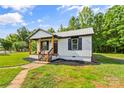 Inviting view of the home's entrance, landscaping and manicured lawn with front porch at 320 E Pine St, Maiden, NC 28650