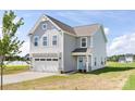 Charming two-story home with gray siding, a two car garage, and a well-manicured lawn at 32562-B Millingport Rd # 7155, New London, NC 28127