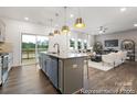 Open kitchen with a gray island, stainless steel appliances, and a view into the adjacent living room and deck at 32562-B Millingport Rd # 7155, New London, NC 28127