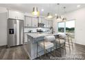 Modern kitchen featuring a gray island with bar seating, stainless steel appliances, and gray cabinets at 32562-B Millingport Rd # 7155, New London, NC 28127