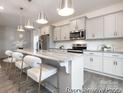 Bright kitchen featuring stainless steel appliances, gray cabinets, granite countertops and an island with barstool seating at 32562-B Millingport Rd # 7155, New London, NC 28127