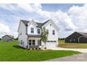Charming two-story home boasts white siding, black roof, and lush green lawn under a partly cloudy sky at 32616 Millingport Rd # 7144, New London, NC 28127