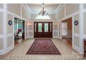 Grand foyer with tile flooring, statement chandelier, and double doors at 3504 High Ridge Rd, Charlotte, NC 29270