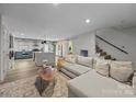 Open-concept living space with a stylish sofa, wood floors, and a glimpse of the modern kitchen at 3528 Colony Rd # A, Charlotte, NC 28211