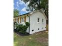 Side view of home with well maintained white painted brick and dark rain gutters at 3700 Denson Pl, Charlotte, NC 28215