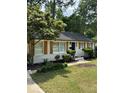 A well-maintained single-story house featuring charming wooden shutters and lush greenery at 3700 Denson Pl, Charlotte, NC 28215
