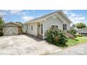 Quaint one-story house with light siding, complemented by a detached garage and a paved driveway at 380 Woodlawn Ave, Cramerton, NC 28032