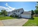 A two-story home with a two-car garage boasts a lush green lawn and a paved driveway at 4075 Clover Nw Rd, Concord, NC 28027