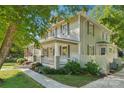 Classic two-story home with a welcoming porch, well-maintained landscaping, and mature trees providing shade at 448 Union S St, Concord, NC 28025