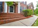 Charming front porch with brick stairs, white columns and mature landscaping at 5004 Woodview Ln, Matthews, NC 28104