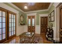 Inviting entryway with wood-paneled walls, doors, and vintage furniture accents at 504 S Hayne St, Monroe, NC 28112