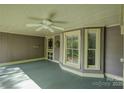 Inviting covered porch with painted wood floors, ceiling fan, and charming architectural details at 504 S Hayne St, Monroe, NC 28112