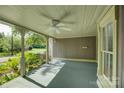 Inviting covered porch with painted wood floors, ceiling fan, and view of the garden at 504 S Hayne St, Monroe, NC 28112