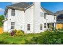 The home's backyard features lush greenery, a white fence, and ample space at 5227 Eagle Creek Dv, Charlotte, NC 28269
