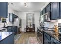 Well-lit kitchen with stainless steel appliances, dark-blue cabinets, and elegant countertops at 6107 Raisin Tree Ln, Charlotte, NC 28215