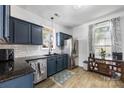 Inviting kitchen with stainless appliances, a classic window view and dark-blue cabinetry at 6107 Raisin Tree Ln, Charlotte, NC 28215
