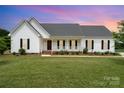 Charming single-story home featuring a covered front porch, manicured lawn, and classic architectural details at 6201 New Hope Church Rd, Marshville, NC 28103