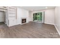 Bright living room featuring a fireplace, built-in shelving, and sliding glass doors to the outside at 7026 Quail Hill Rd, Charlotte, NC 28210