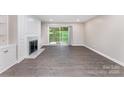 Spacious living room with a fireplace, built-in shelving, and sliding glass doors to the outside at 7026 Quail Hill Rd, Charlotte, NC 28210