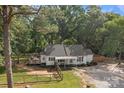 Picturesque home exterior with a spacious deck, fenced yard, and lush trees offering privacy and outdoor enjoyment at 800 Woodlawn St, Belmont, NC 28012
