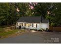 Inviting home exterior featuring a cozy porch swing, landscaped yard, and outdoor lighting for evening ambiance at 800 Woodlawn St, Belmont, NC 28012