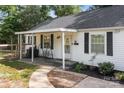 Attractive home exterior with a covered porch, black shutters, and landscaping, offering a blend of comfort and appeal at 800 Woodlawn St, Belmont, NC 28012