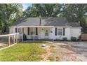 Welcoming home exterior featuring a covered porch, manicured lawn, and fenced yard, blending charm and functionality at 800 Woodlawn St, Belmont, NC 28012