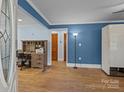 Bright living room with hardwood floors, blue walls, and a wooden desk; adjacent to the entry at 800 Woodlawn St, Belmont, NC 28012