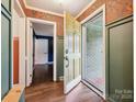 Bright foyer features stylish wallpaper, beautiful hardwood flooring, and ample natural light at 827 Fairbanks Rd, Charlotte, NC 28210