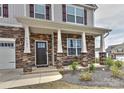 Inviting front porch with stone facade, white columns, and a well-maintained garden at 9505 Cotswood Pl, Gastonia, NC 28056