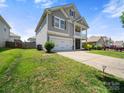 View of the side exterior featuring the well maintained lawn, driveway and two car garage of this home at 10426 Kempsford Dr, Charlotte, NC 28262