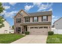 Two-story home with stone and siding, complemented by a green lawn and a convenient two-car garage at 12822 Plumleaf Dr, Charlotte, NC 28213