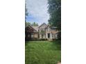 Beautiful two-story brick home with symmetrical design, complemented by lush green lawn and mature trees at 15494 Donnington Dr, Charlotte, NC 28277