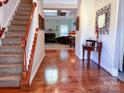 Inviting foyer with hardwood floors, staircase, and an open view into the living room with fireplace at 15494 Donnington Dr, Charlotte, NC 28277