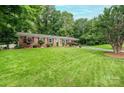 Inviting single-story brick home with a green lawn, mature trees, and an attached carport at 1571 10Th Street Nw Pl, Hickory, NC 28601