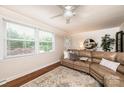 Bright living room features a cozy leather couch, large window, ceiling fan, and modern decor at 1571 10Th Street Nw Pl, Hickory, NC 28601
