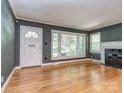 Bright living room featuring hardwood floors, large windows, and a classic fireplace at 1720 Chatham Ave, Charlotte, NC 28205