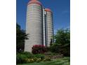 Unique grain silo conversion opportunity for creative home, nestled in the trees with bright blooms at 2408 Salute Blvd, Mint Hill, NC 28227