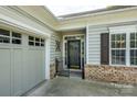 Inviting entrance features a decorative security gate, brick accents, and adjacent garage access for added convenience and curb appeal at 2598 Old Ashworth Nw Ln, Concord, NC 28027