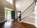 Welcoming foyer with high ceilings, hardwood floors, and staircase with metal spindles at 2652 Bedford Nw Pl, Concord, NC 28027