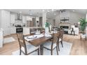 A dining room features a wooden table set for six, complemented by modern lighting and an open view to the kitchen at 4949 Rimer Rd # 4, Concord, NC 28025