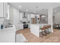 Modern kitchen features white cabinetry, stainless steel appliances, and an island with barstool seating, offering a functional layout at 4949 Rimer Rd # 4, Concord, NC 28025