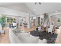 Bright open-concept living area with vaulted ceilings, light hardwood flooring, and modern decor adjacent to kitchen at 4949 Rimer Rd # 4, Concord, NC 28025