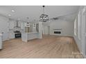 Open floor plan with a living room featuring a vaulted ceiling, modern fireplace and light, wood-look floors at 4975 Rimer Rd # 1, Concord, NC 28025