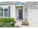 Inviting entryway with a decorative door, stone accents, and lush landscaping enhancing curb appeal at 5058 Antebellum Dr, Iron Station, NC 28080