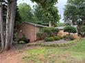 Brick home with a lush green lawn, mature trees, and a wooden deck with ramp access at 5198 Wright Dr, Hickory, NC 28602